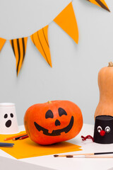 Holiday preparation and handmade party decor. Halloween indoor activity, pumpkin painting