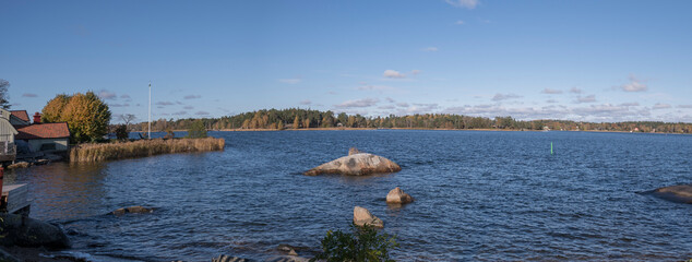 View over a bay with rocks in the old town Vaxholm in the archipelago of Stockholm a color full autumn day