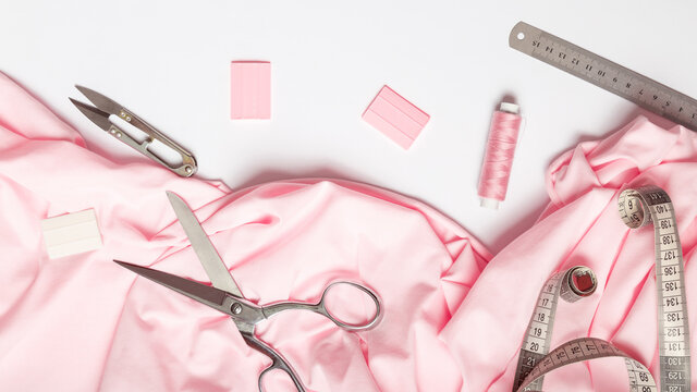 Woman hobby. Set for tailor shop with scissors, sewing tools, pink fabric on white background top view - Powered by Adobe