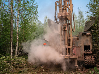 Crawler drilling rig drills a well, a lot of dust when drilling a borehole