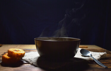 Pumpkin soup puree in a brown plate on a wooden table