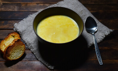 Pumpkin soup puree in a brown plate on a wooden table