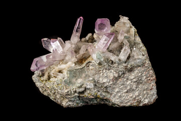 Macro mineral stone Amethyst crystals in rock on a black background
