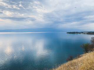 Fototapeta premium White cloudy sky reflection on the surface of the blue lake