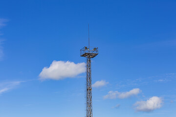 Obraz premium Old high radar tower against a bright blue sky