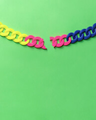 Colorful freedom concept. Neon breaking chain on green background. Minimalistic escape idea.
