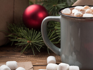 Hot chocolate with marshmallows and Christmas decor on a wooden table. Copy space.