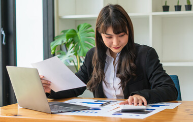 beautiful Asian business women checking document and using notebook and smiling happy for working