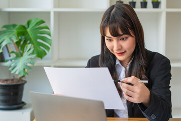 Portrait Of Attractive Asian Businesswoman Working On Laptop for marketing plan