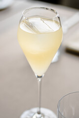 Beautiful yellow cocktail with an ice cube at a restaurant