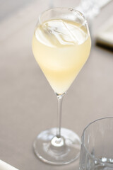 Beautiful yellow cocktail with an ice cube at a restaurant