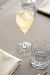 Beautiful yellow cocktail with an ice cube at a restaurant
