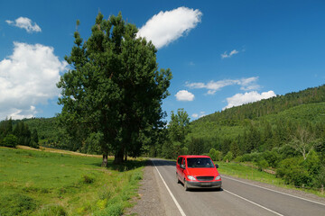 Red car driving on scenic road