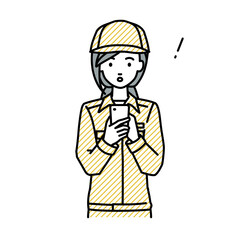 立ってスマートフォンを操作して何かに気づいて驚いた作業員の女性
