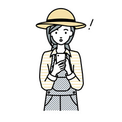 立ってスマートフォンを操作して何かに気づいて驚いた農家の女性