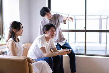 家でテレビゲームをする若い男女