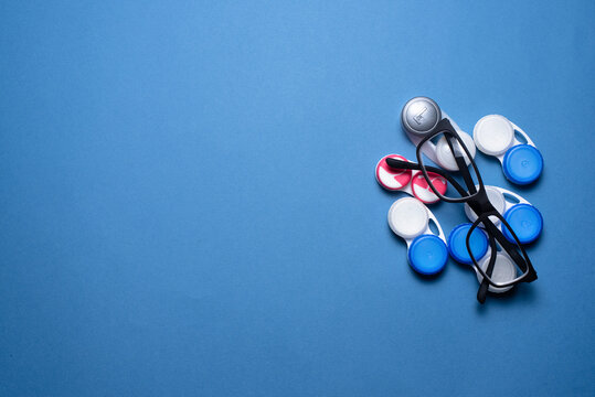 Contact Lenses And Eye Glasses On The Blue Flat Lay Background.