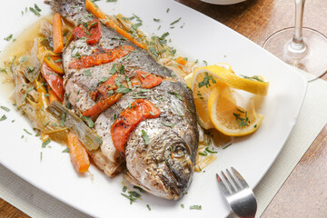 Grilled fish with tomato sauce and lemon slices