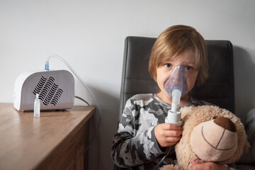 Chory chłopiec przy stole z inhalatorem - obrazy, fototapety, plakaty