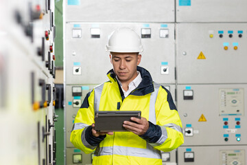 Technician inspect to control panel screen system for generate electricity of factory in manufacture industrial. Man electrical engineer hold tablet monitoring electrical system in control room