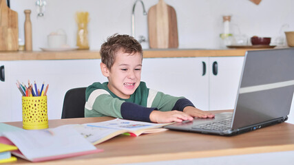 boy is studying at an online school, showing the answer to the question via video communication