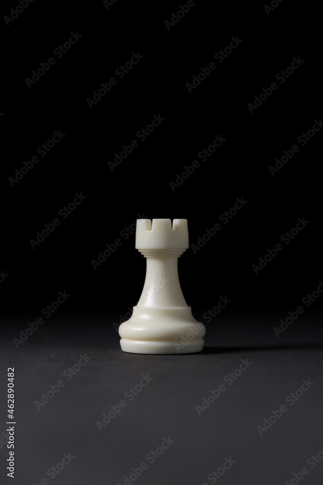 Wall mural isolated white rook chess piece on black background.