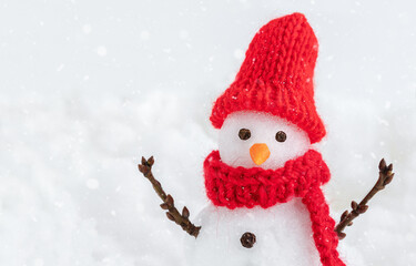 Snowman in red hat and scarf on the snow background	
