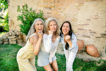 Portrait of three excited women of different age cheering