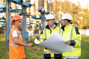 Two Industrial Engineers Talk with Factory Worker a drawing on paper in the open air against the...