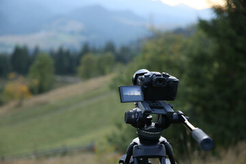 Taking photo of beautiful mountain landscape with camera mounted on tripod outdoors, space for text