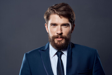 bearded man jacket with tie dark background