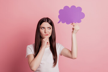 Photo of young attractive girl think hmm deep hold paper cloud speak speech isolated over pink color background