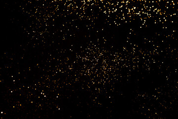 Golden abstract bokeh on black background.