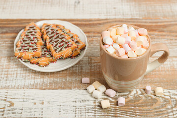 Cup of coffee with marshmallow and Christmas cookies in form of fir tree at the background. New Year's and Christmas festive cooking