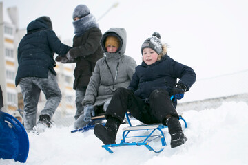 Fototapeta na wymiar A group of children sledding on a winter day.