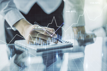 Double exposure of abstract creative financial chart with hand writing in notebook on background, research and strategy concept