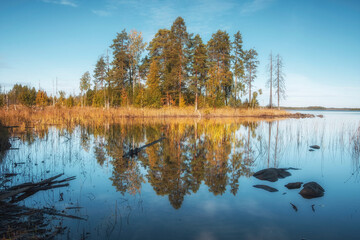 Island and reflection in northern Lake Onega in Karelia, Russia in early autumn. Northern Europe landscape.