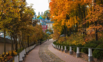Naklejka premium road to beautiful churches in the Dormition Pskovo Pechersky Monastery in the city of Pechery, Pskov Region, Russia during the golden autumn