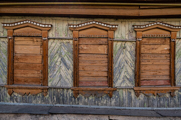three wooden boarded up windows in an old wooden house