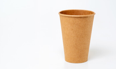 Paper cup made of craft paper on a light white background, place for text.