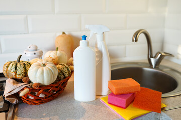 autumn table with dish detergent, Dishwashing liquid with a sponge and pumpkins on kitchen near sink
