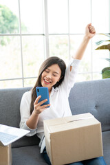 Happy young Asian woman entrepreneur, Smile for sales success after checking order from online...