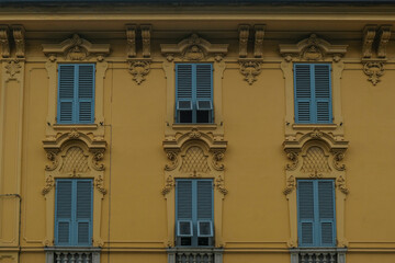 facade of the baroque yellow building with windows and blue shutters in old town. Historical architecture	