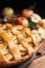 Delicious traditional apple pie on wooden table, closeup
