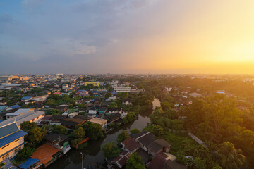 Aerial view of residential houses with nature trees, Wutthakat district, Bangkok City, Thailand in urban city in Asia. Residential houses, buildings at sunset.