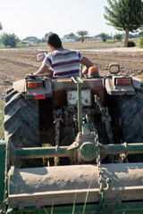 young farmer cultivating the field on his tractor