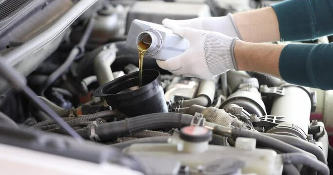 Mechanic pouring engine oil into car 4k movie