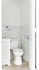 Naklejka na ściany i meble Toilet seat in a bathroom photographed through an open door.