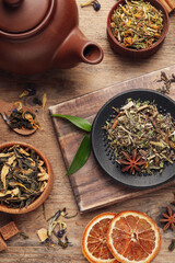Flat lay composition with different dry teas on wooden table