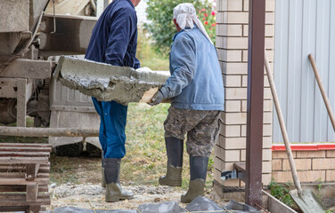 Workers level out the concrete mix at a construction site.